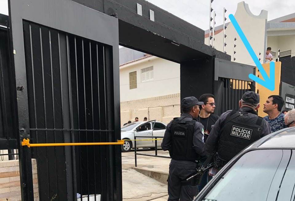 Foto da reconstituição do crime com a presença do suspeito preso